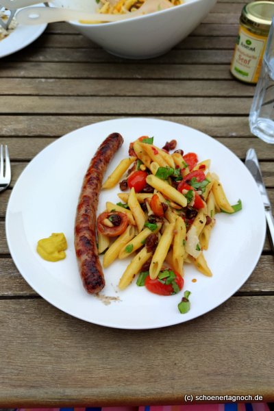 Bratwurst vom Grill mit sizilianischem Pastasalat mit Kirschtomaten, Rosinen, gerösteten Pinienkernen, Oliven und frischen Kräutern